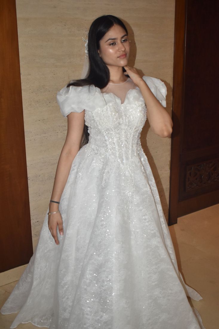 Bride in a lace gown with organza puff sleeves and a long veil